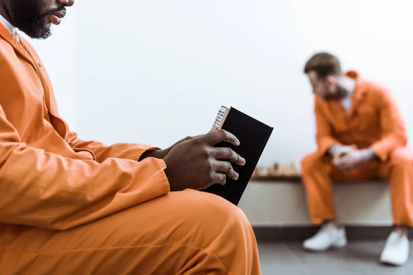 Imagen recortada de prisionero afroamericano libro de lectura - foto de stock