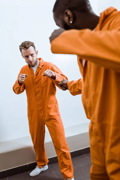 Multicultural prisoners fighting in prison room — Stock Photo
