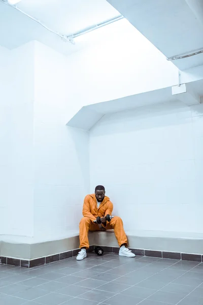 Prisionero afroamericano en celda de prisión moderna de luz - foto de stock