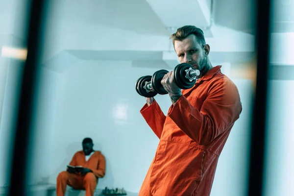 Entrenamiento de prisioneros con pesas en sala de prisión - foto de stock