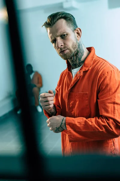 Prisoner looking at camera behind prison bars — Stock Photo