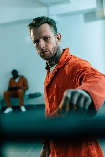 Multiethnic prisoners in prison cell behind prison bars — Stock Photo