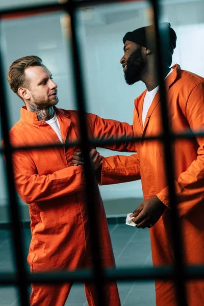 Prisionero caucásico comprando drogas a preso afroamericano en celda de prisión - foto de stock