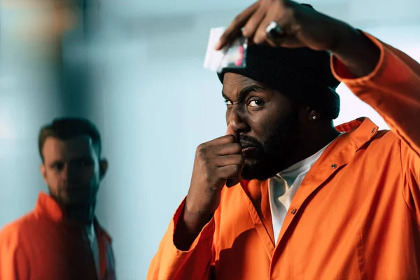 African american prisoner holding drugs at prison cell — Stock Photo