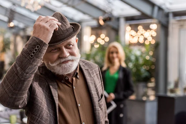 Focalizzazione selettiva dell'uomo anziano sorridente in cappello nel ristorante — Foto stock