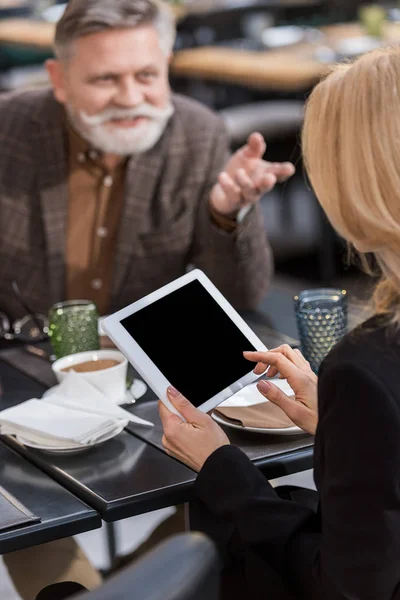 Tiro cortado de empresária usando tablet durante reunião com colega no café — Fotografia de Stock