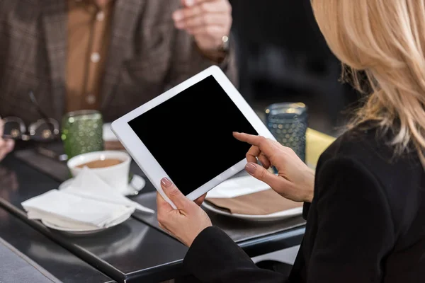 Plan recadré de femme d'affaires en utilisant une tablette lors d'une réunion d'affaires avec un collègue dans un café — Photo de stock