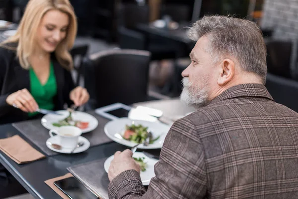 Вибірковий фокус старшого чоловіка на романтичному побаченні з дівчиною в кафе — стокове фото