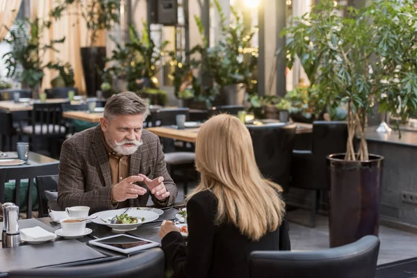 Vista parcial del hombre y la mujer mayores cenando juntos en el restaurante - foto de stock