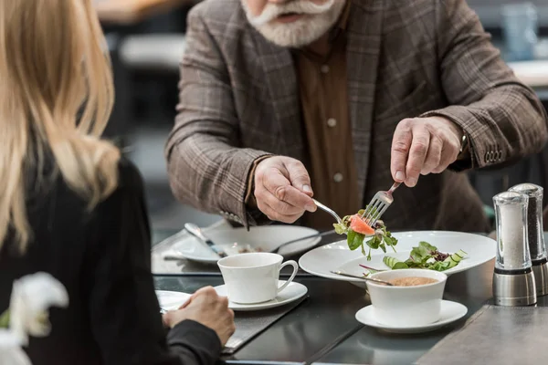 Vista parcial del hombre y la mujer cenando juntos en el restaurante - foto de stock