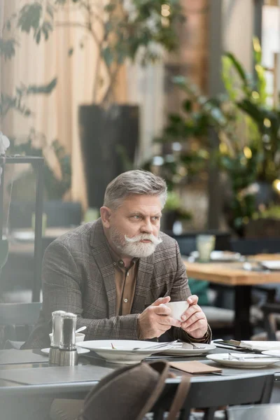 Retrato de homem sênior com xícara de café no café — Fotografia de Stock