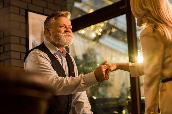 Visión parcial de los socios de negocios estrechando la mano después de la reunión de negocios en la cafetería - foto de stock