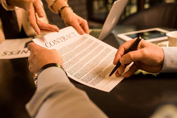 Hombre de negocios firmar contrato durante la reunión con un colega de negocios en la cafetería - foto de stock