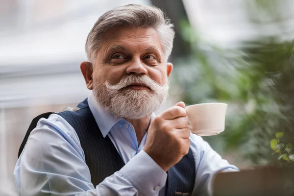 Portrait de l'homme barbu senior avec tasse de café dans le café — Photo de stock