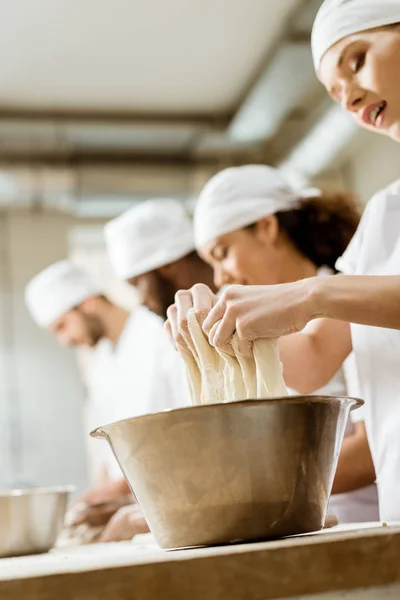 Plano de primer plano del grupo de los trabajadores de la fabricación de hornear amasando masa juntos — Stock Photo