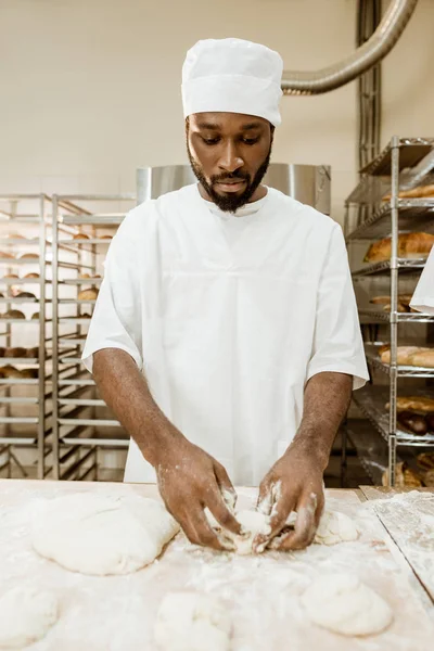 Padeiro afro-americano bonito preparando massa crua para pastelaria na fabricação de panificação — Fotografia de Stock