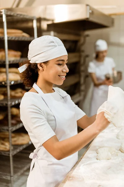 Femme boulanger afro-américain pétrissant pâte à la fabrication de cuisson — Photo de stock