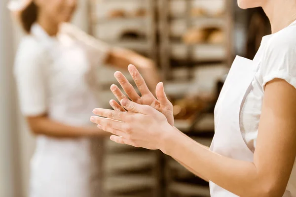 Plan recadré de boulanger femelle avec les mains couvertes de farine à la fabrication de cuisson — Photo de stock