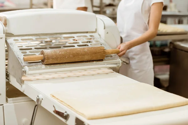 Cropped shot of female baker with list raw dough on baking manufacture — Stock Photo