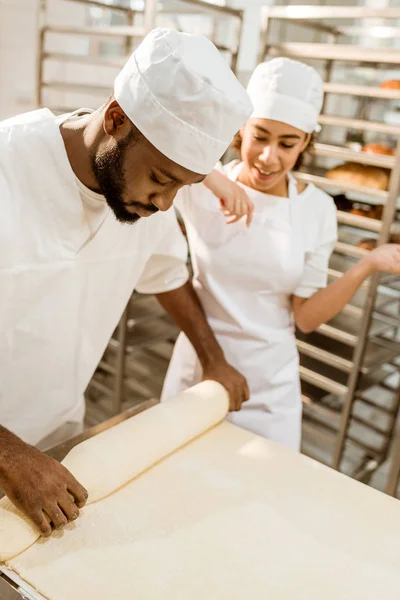 African american bakers working with industrial dough roller at baking manufacture — Stock Photo