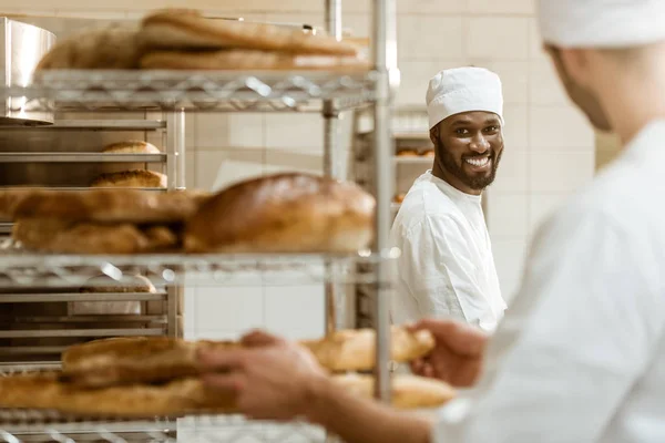 Young bakers working together at baking manufacture — Stock Photo