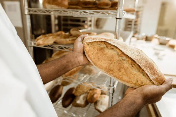 Panificadora de xisto cortado segurando pão fresco na fabricação de panificação — Fotografia de Stock