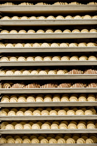 Raw croissants on shelves in industrial oven — Stock Photo