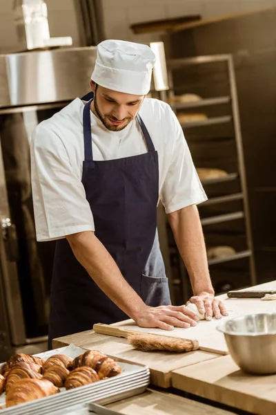 Baker kneading dough for pastry on baking manufacture — Stock Photo