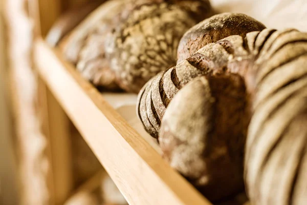 Close-up shot of various rural bread on shelf at pastry store — Stock Photo
