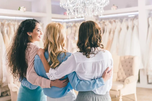 Novias mirando vestidos de encaje en el salón de bodas - foto de stock