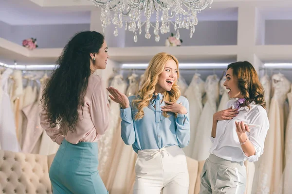 Las mujeres jóvenes se divierten en la tienda de moda de boda - foto de stock