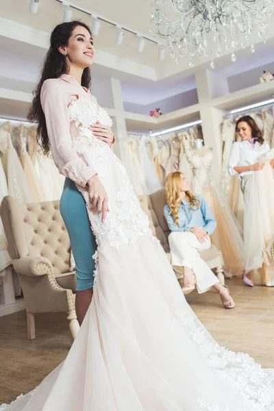 Sposa con abiti di pizzo e damigelle d'onore in atelier di nozze — Foto stock