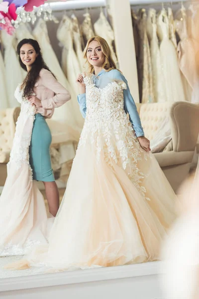 Novias sosteniendo vestidos de encaje en el salón de bodas - foto de stock