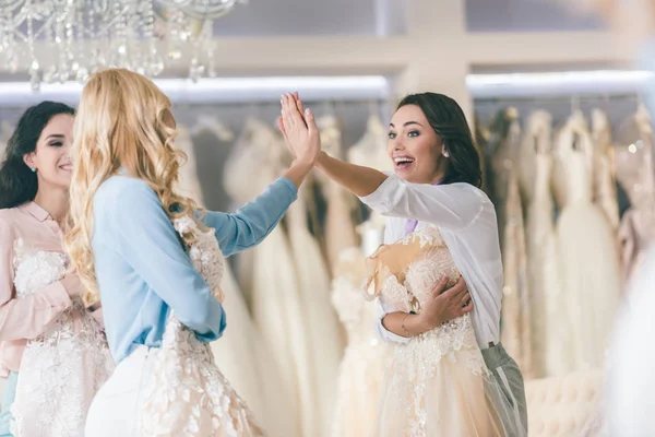 Young smiling brides giving high five in wedding atelier — Stock Photo