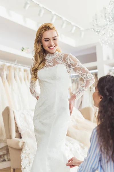 Bride in lace dress and tailor in wedding salon — Stock Photo