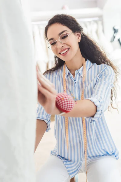 Ago donna pinning dettagli del vestito in negozio di moda di nozze — Foto stock