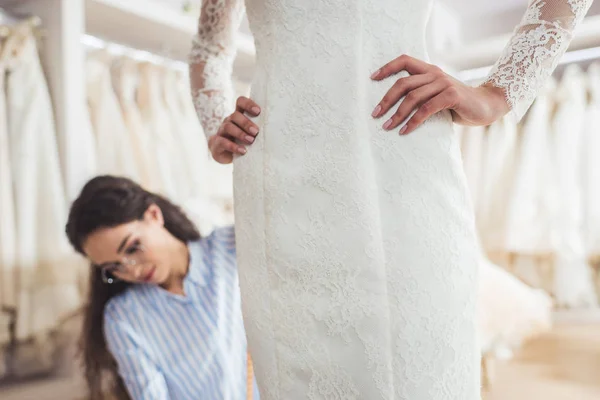Sarto femminile che lavora da sposa in atelier di nozze — Foto stock