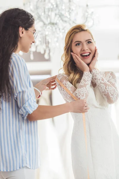 Noiva em vestido de renda e alfaiate no atelier de casamento — Fotografia de Stock