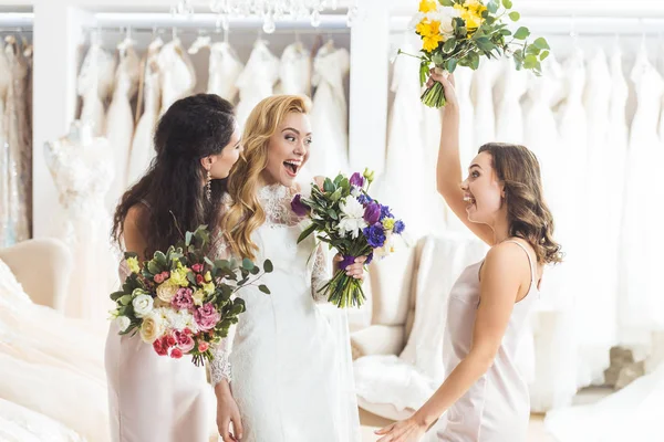 Mujeres sonrientes en vestidos de novia con flores en el taller de bodas - foto de stock