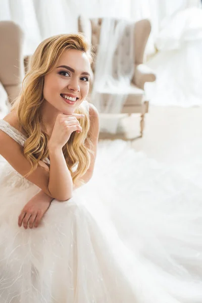 Smiling bride wearing tulle dress in wedding atelier — Stock Photo