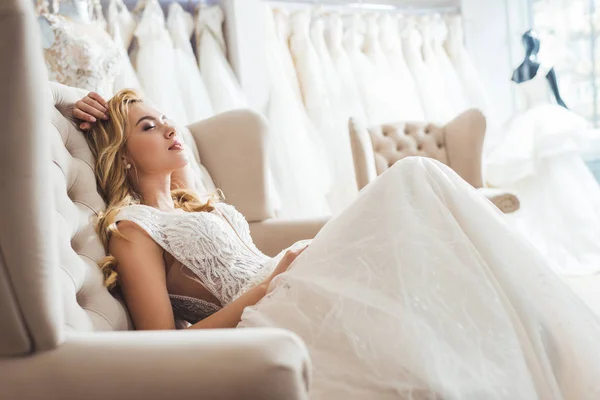 Atractiva novia en vestido de tul en la tienda de moda de boda - foto de stock