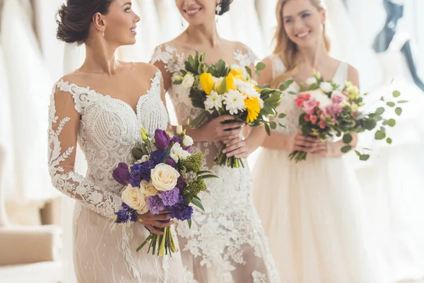 Привлекательные женщины в свадебных платьях смеются в свадебном салоне — Stock Photo