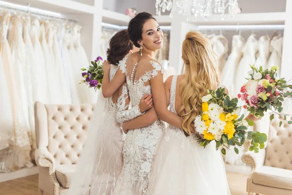 Novias en vestidos de encaje con flores en atelier de boda - foto de stock