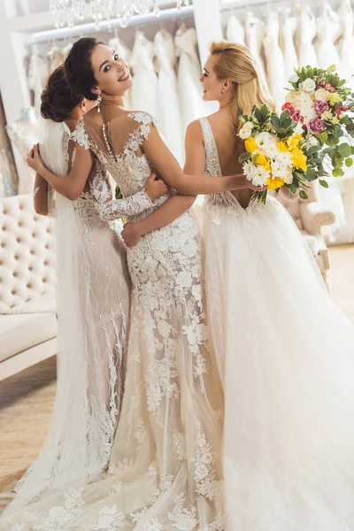 Young smiling brides with bouquets in wedding atelier — Stock Photo