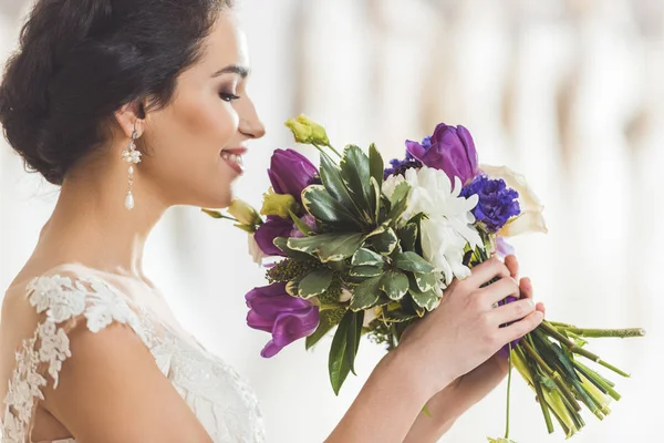 Giovane sposa con mazzo di fiori in atelier di nozze — Foto stock