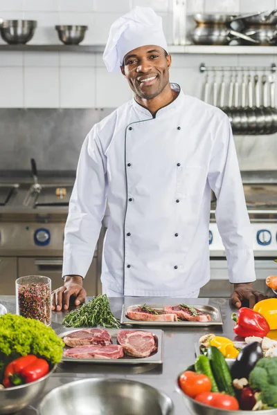 Chef americano africano bonito olhando para a câmera na cozinha do restaurante — Fotografia de Stock