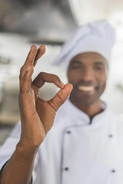 Bello africano americano chef mostrando ok gesto a ristorante cucina — Stock Photo