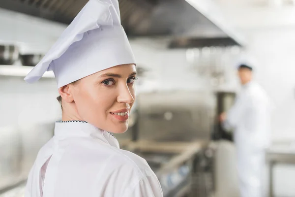 Portrait of attractive chef looking at camera at restaurant kitchen — Stock Photo