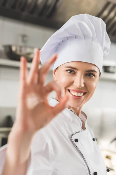 Attraktive Köchin zeigt in Restaurantküche Okay-Geste — Stockfoto