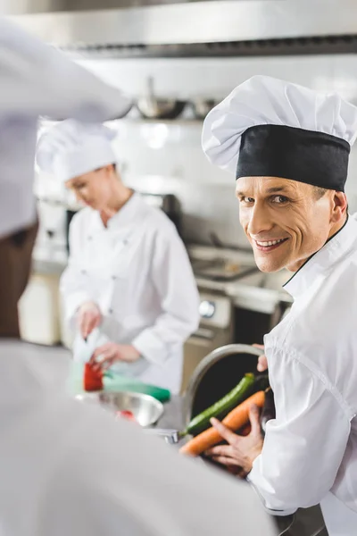 Chefs multiculturales cocinando en la cocina del restaurante - foto de stock